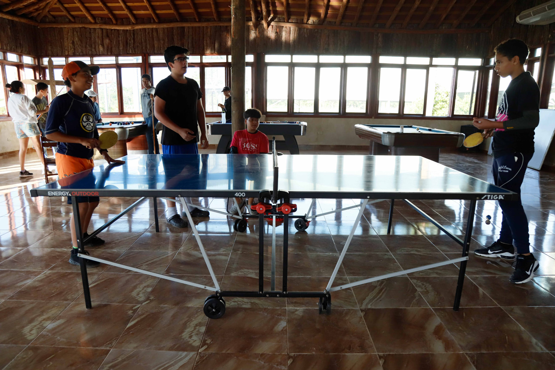 Jóvenes jugando ping pong en el rancho