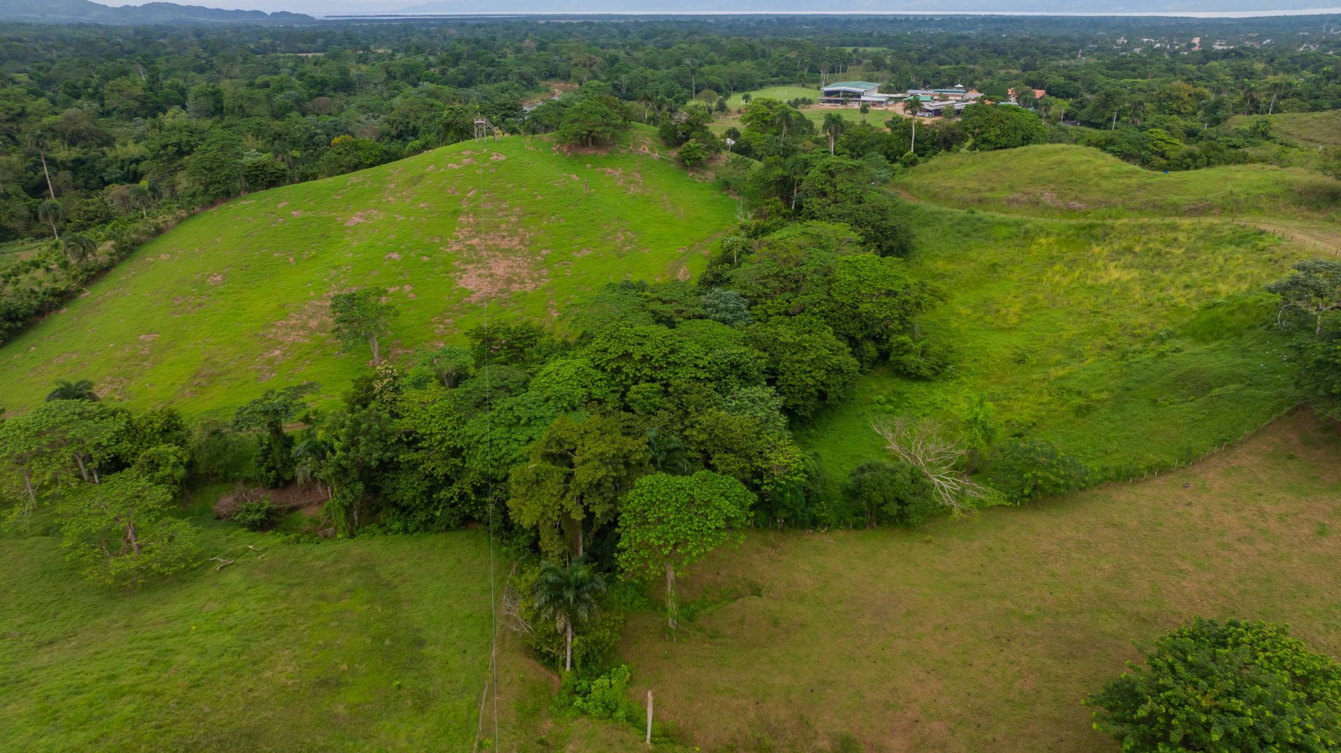 Panorámica aérea del cable del zipline sobre las lomas