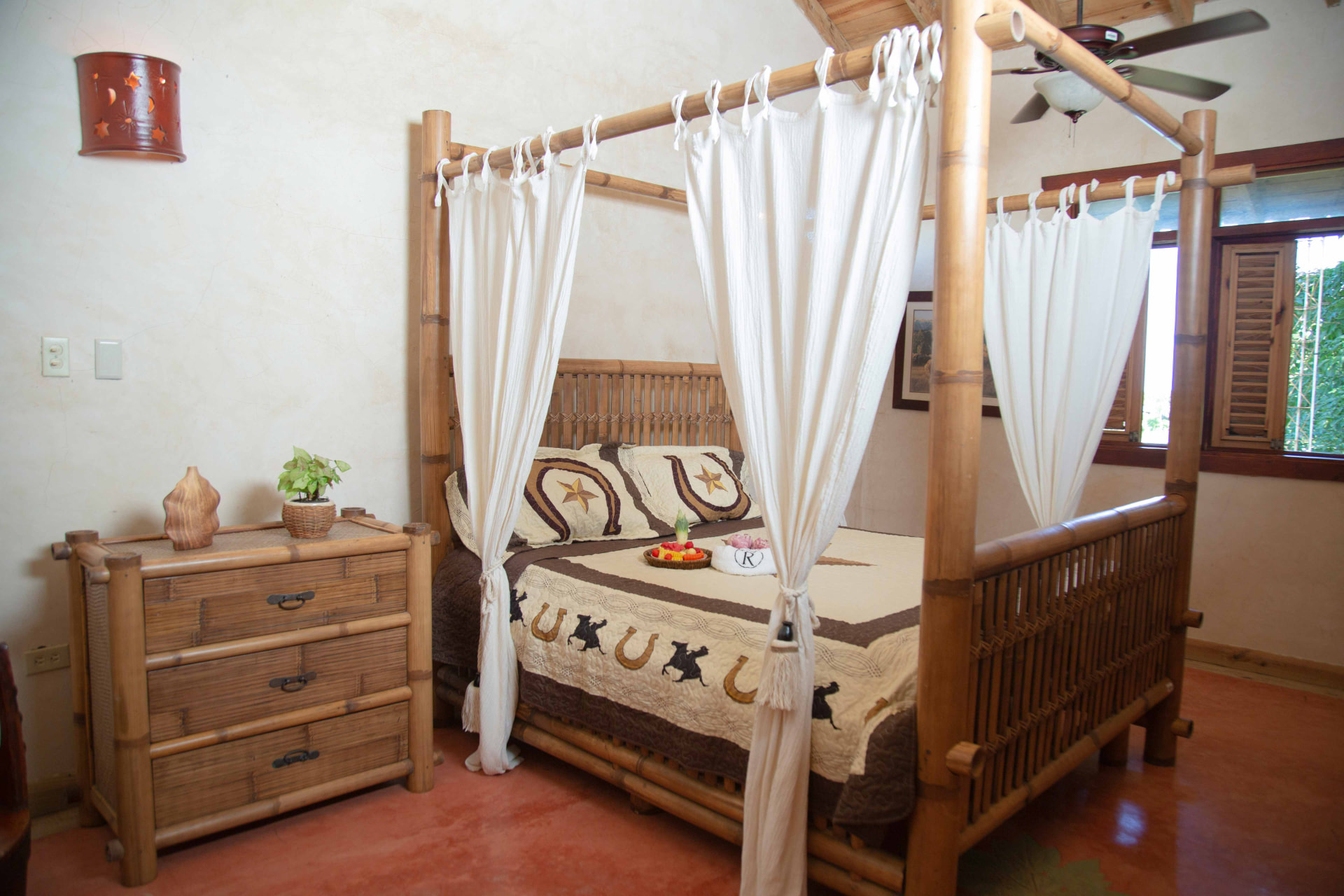 Habitación rústica con cama de bambú con dosel