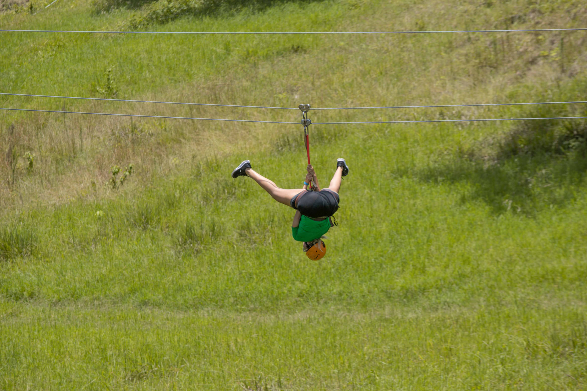 Persona descendiendo por el zipline del rancho