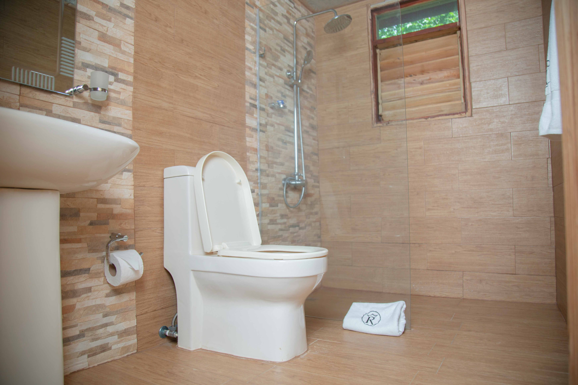 Baño privado con ducha de lluvia y acabados en madera
