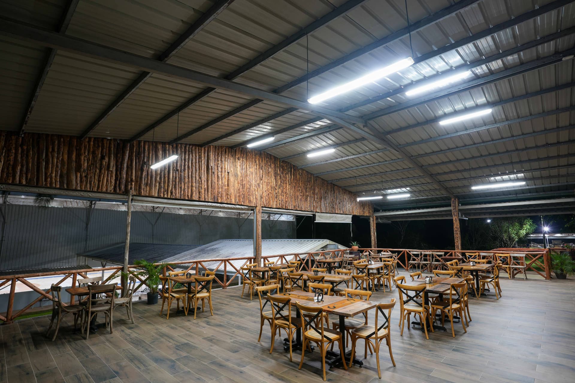 Terraza techada del restaurante con mesas de madera