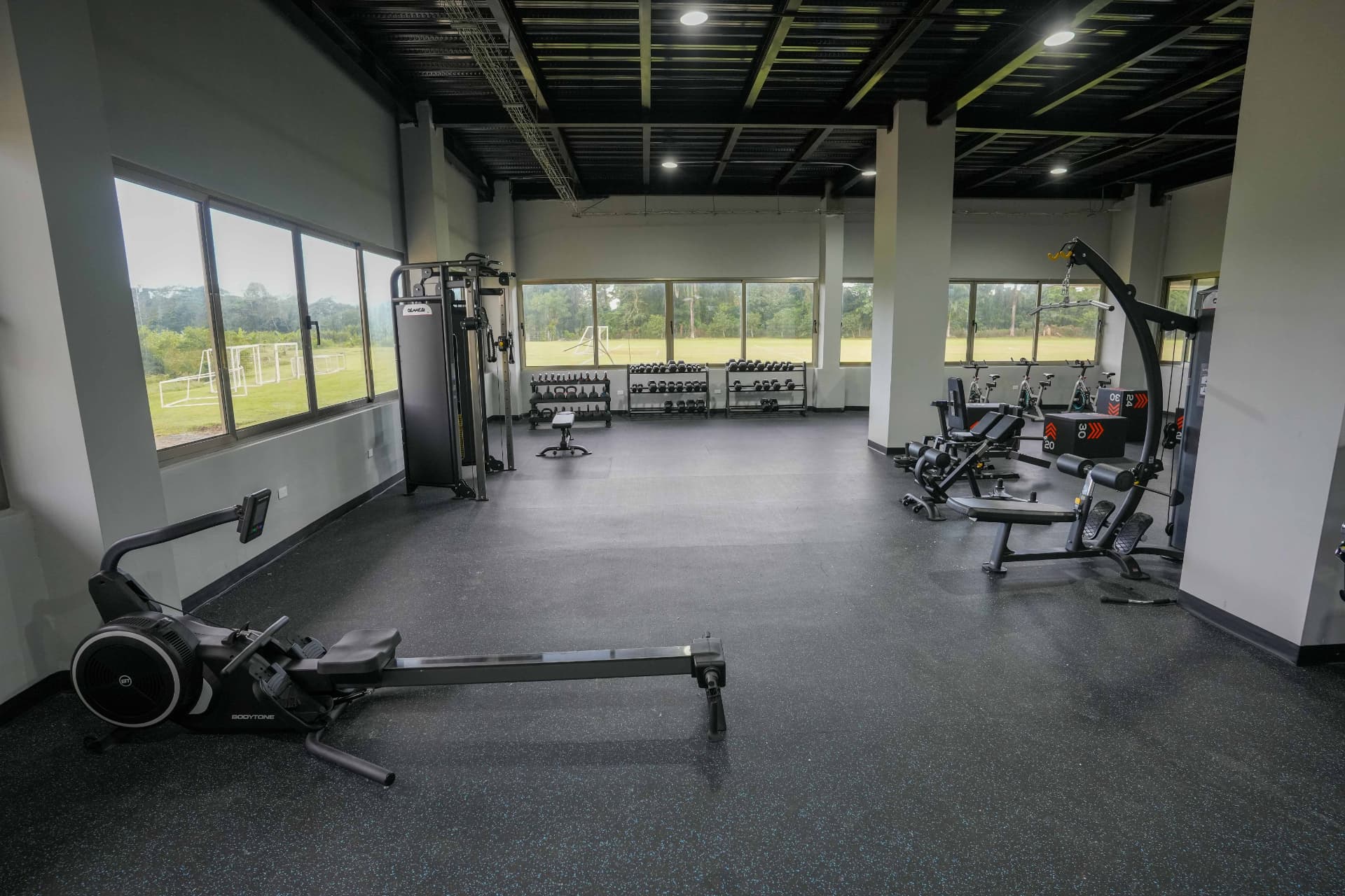 Máquina de remo y zona cardio con vista a la cancha