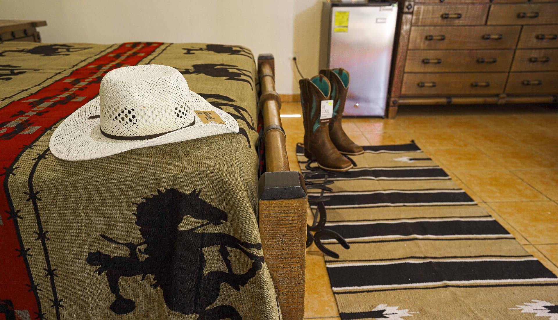 Detalles vaqueros: sombrero, botas y nevera en la habitación