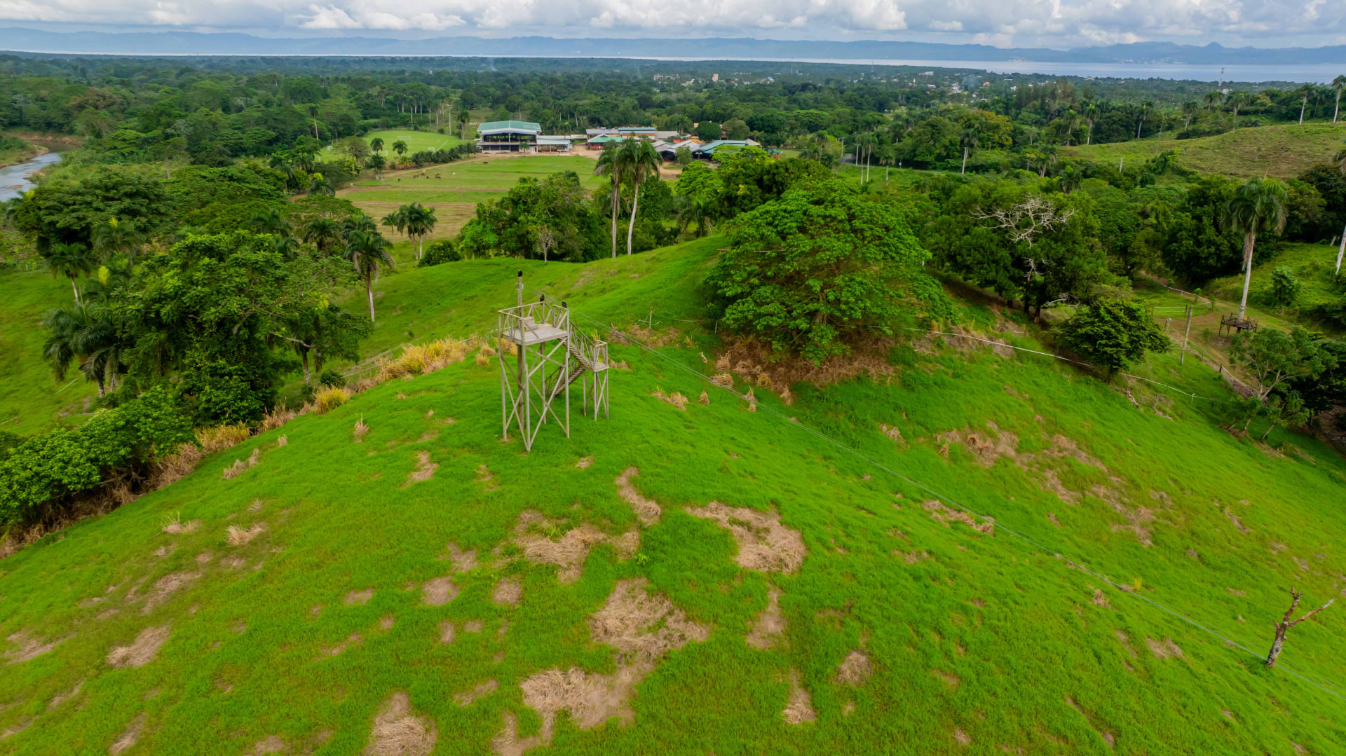 Torre del zipline con vista al rancho y la bahía
